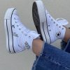 Une paire de baskets personnalisée couleur blanche avec du feuillage vert