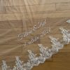 Voile de mariée brodé posé sur du parquet