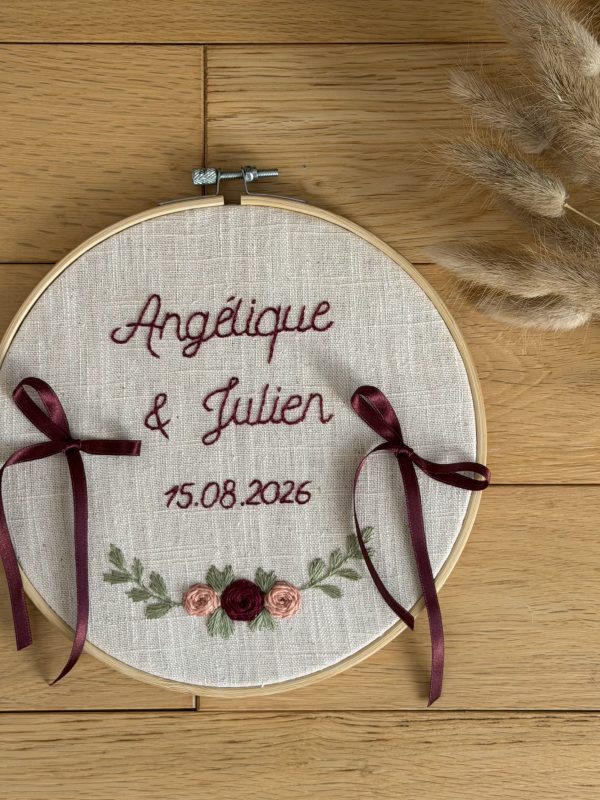 Porte alliance posé au sol. Broderie des prénoms des mariées ainsi que de la date du mariage