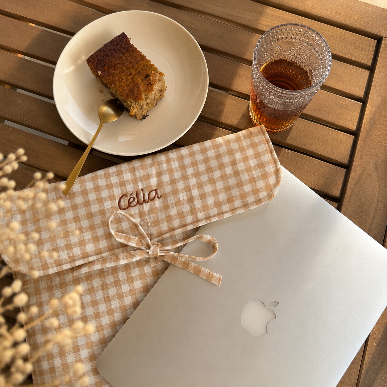 Housse D"ordinateur posé sur une table avc un gateau et un jus